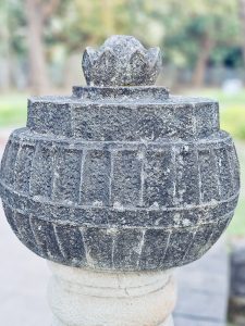 A black stone ornamental structure with a lotus-shaped top, placed in the Elephanta caves, Mumbai, Maharashtra. 