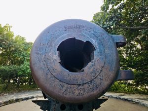 A close-up of the historic cannon at the Elephanta Caves in Mumbai. The worn metal surface and the broken inner parts reveal its age and the long history behind this structure. 