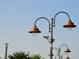 Classic street lamps with a CCTV camera below them, standing tall under the bright blue sky. It was captured from Bandra West, Mumbai, Maharashtra.