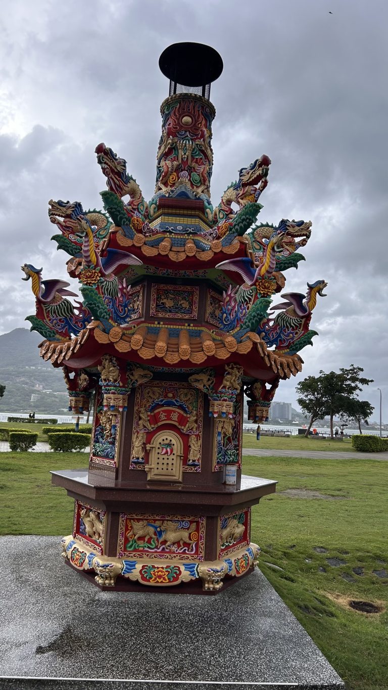 A colorful ornate structure resembling a traditional pagoda, adorned with intricate dragon sculptures and vibrant decorations.