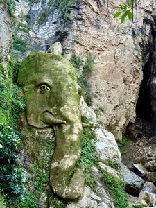 A rock shaped like an elephant&rsquo;s head, symbolizing Lord Ganesh, among cliffs and greenery.
