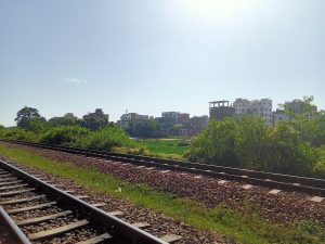 A view of a Railway track with bushes on its sides and buildings at Kawtoli, Brahmanbaria, Bangladesh