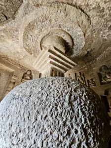 Inside a Kanheri cave, a large stone stupa rises under a carved circular ceiling. This ancient Buddhist structure shows the devotion and skill of early monks. Captured from Borivali, Mumbai.