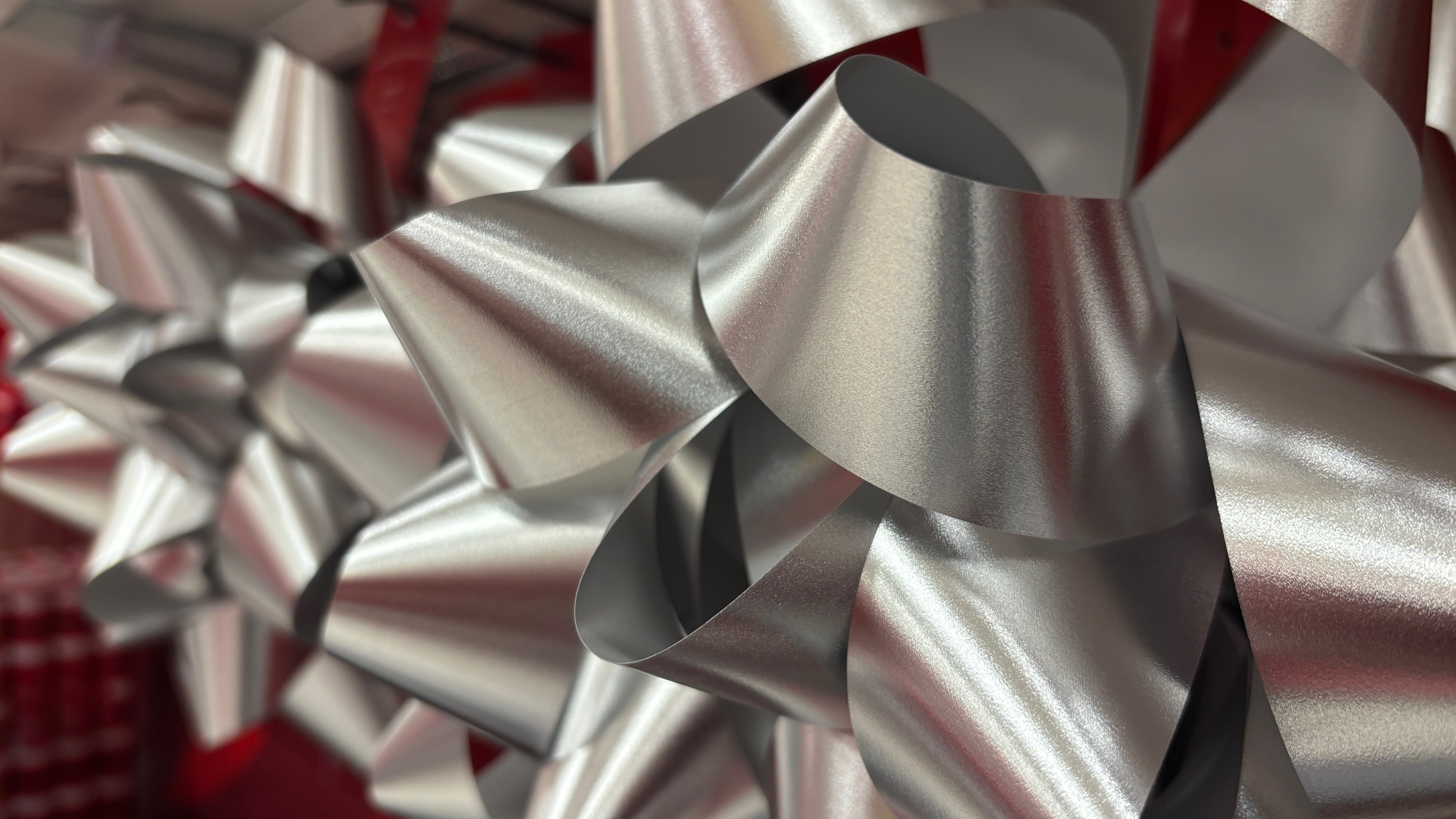 Close-up of a silver gift bow, with a second in the background.