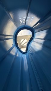 The photo looking up at the Umeda Sky Building in Osaka, Japan, through the blue sculpture in front of it.