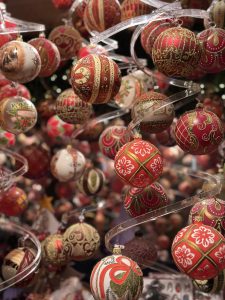 A stunning collection of ornate Christmas baubles, glowing with rich red and gold details, capturing the charm and warmth of the holiday season.