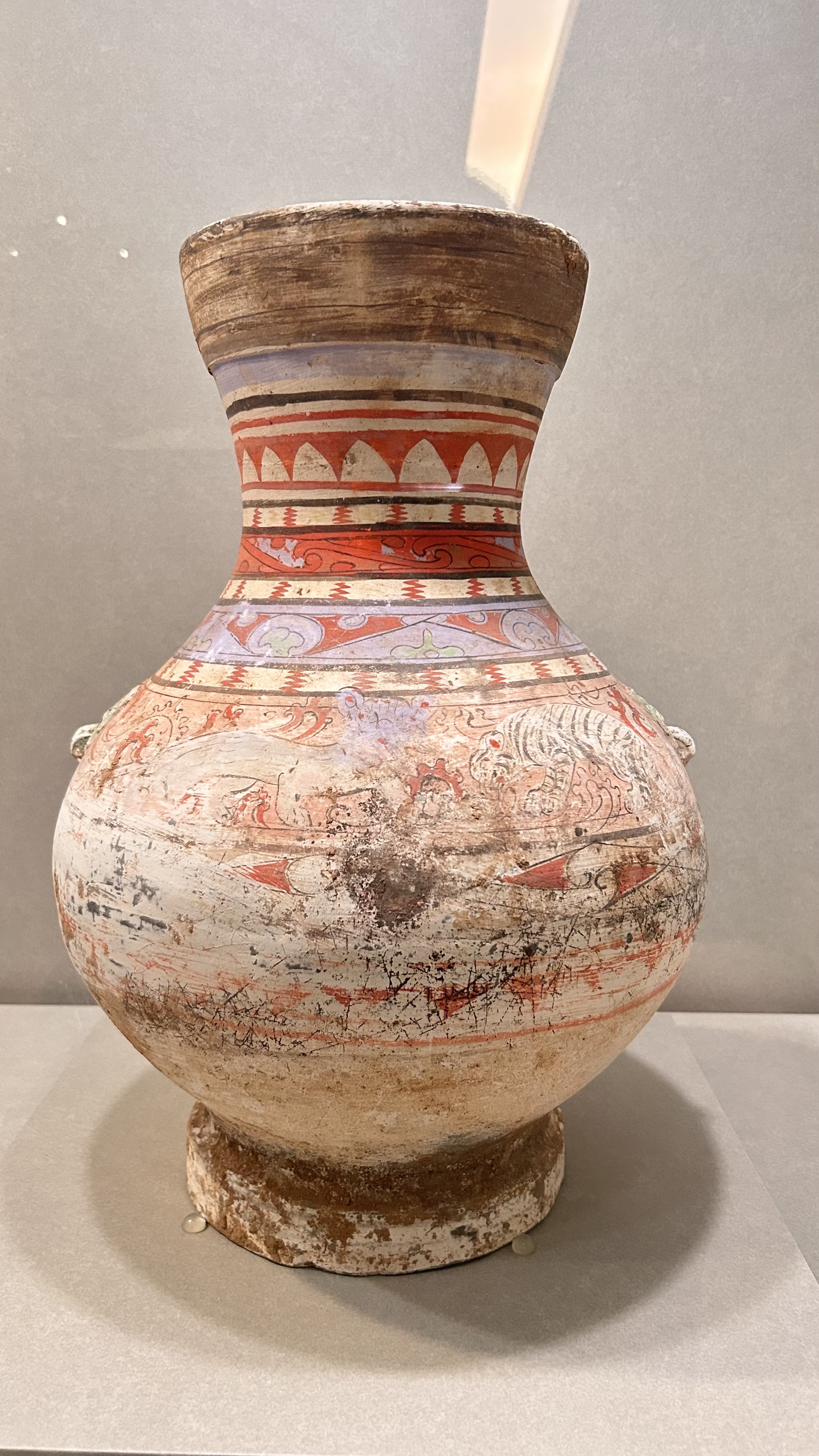 A decorative pottery vessel with a wide belly and narrowed neck, featuring intricate painted designs