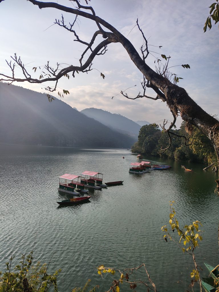 Several small boats and covered paddle boats float near the center of the lake, neatly arranged and appearing ready for tourists