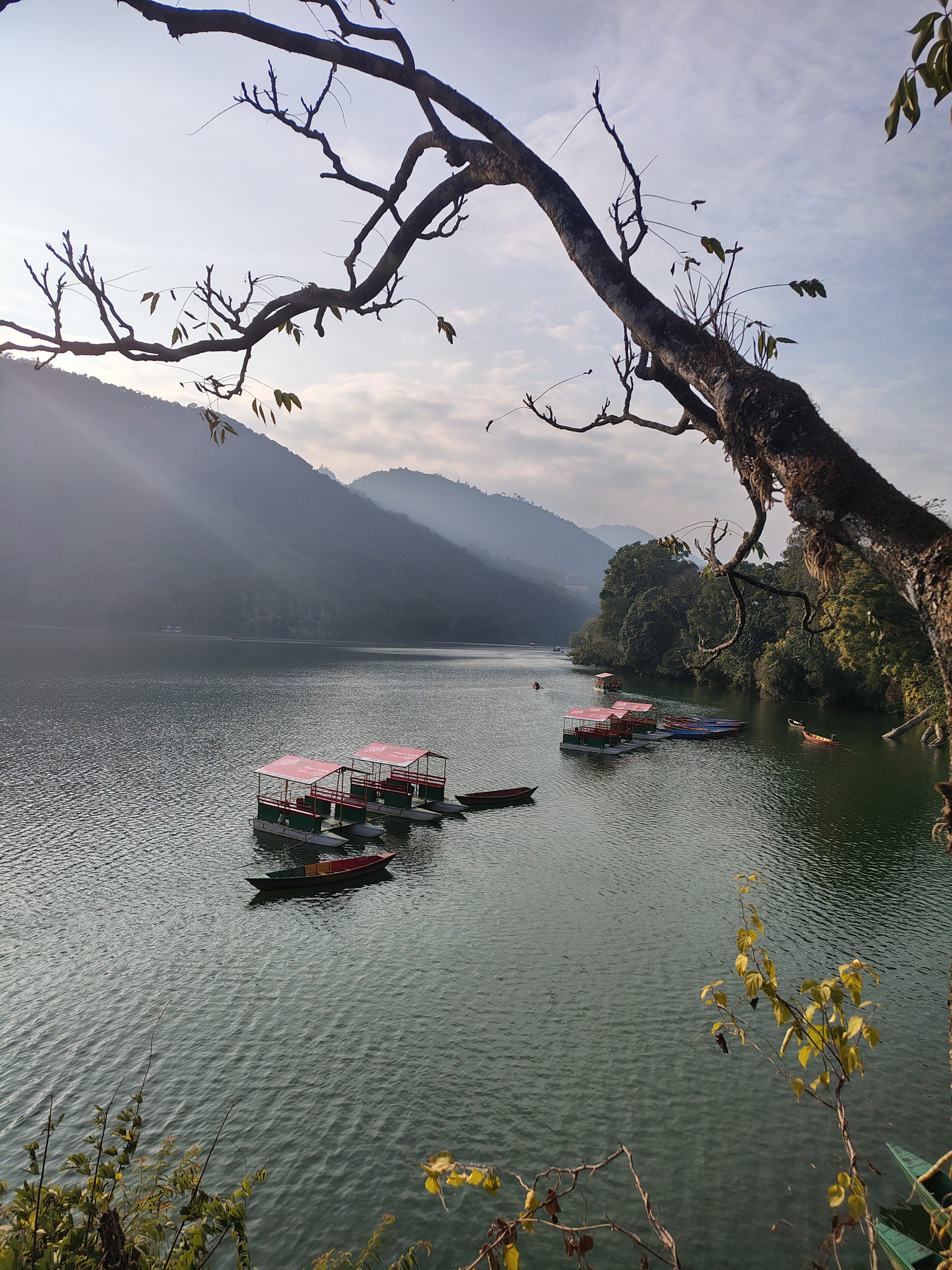 Several small boats and covered paddle boats float near the center of the lake, neatly arranged and appearing ready for tourists