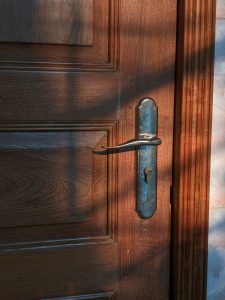 A close-up view of a wooden door featuring a metal handle and lock. 