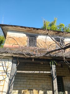 An old building features a weathered exterior with stone walls and wooden beams.