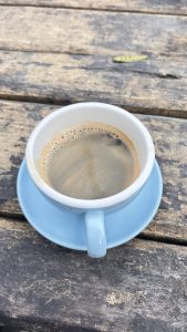 A close-up view of a cup of coffee resting on a light blue saucer.