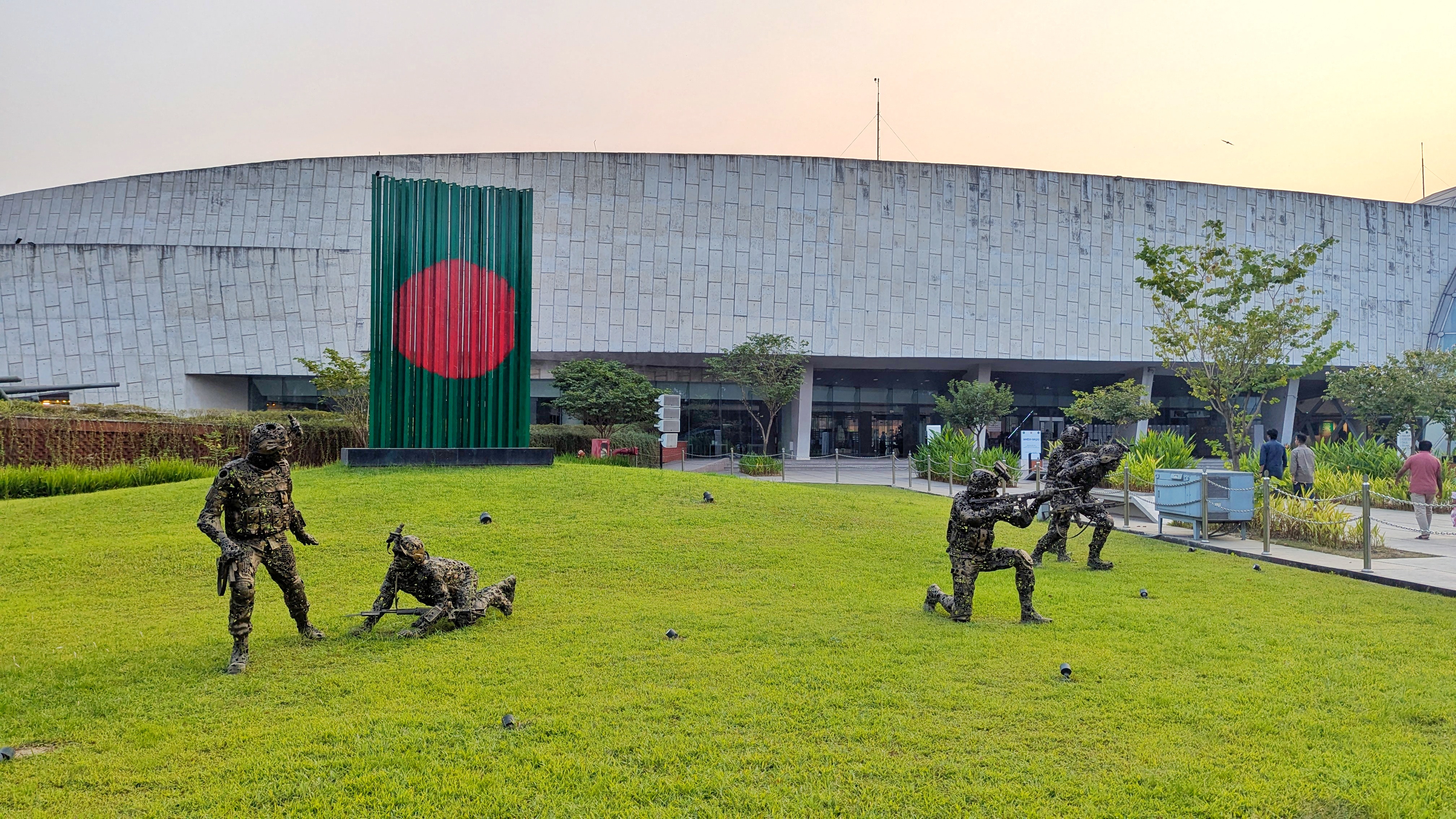 A green lawn with bronze soldier statues at the Army Museum in Dhaka.