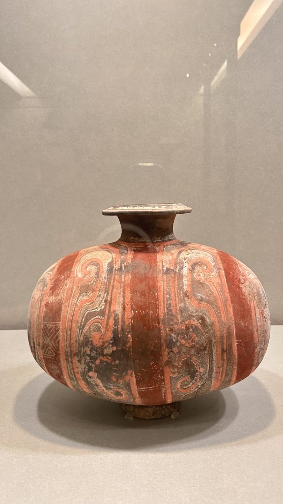 A rounded pottery vase with a flared neck and a flat rim.