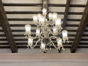 A decorative chandelier featuring multiple light fixtures with glass shades suspended from an ornate structure