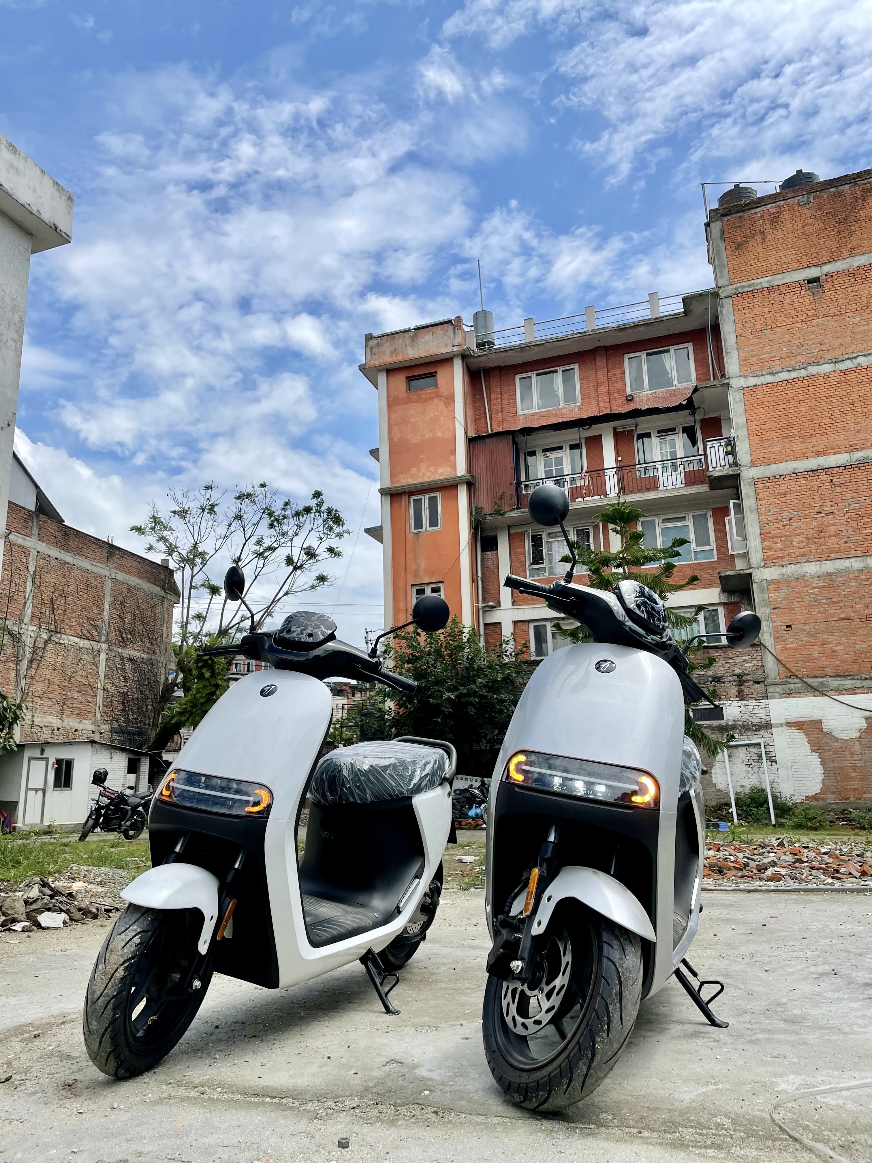 Two brand new electric scooters standing side by side ready for delivery!