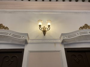 A decorative wall featuring a vintage-style sconce lamp, which emits a warm glow.