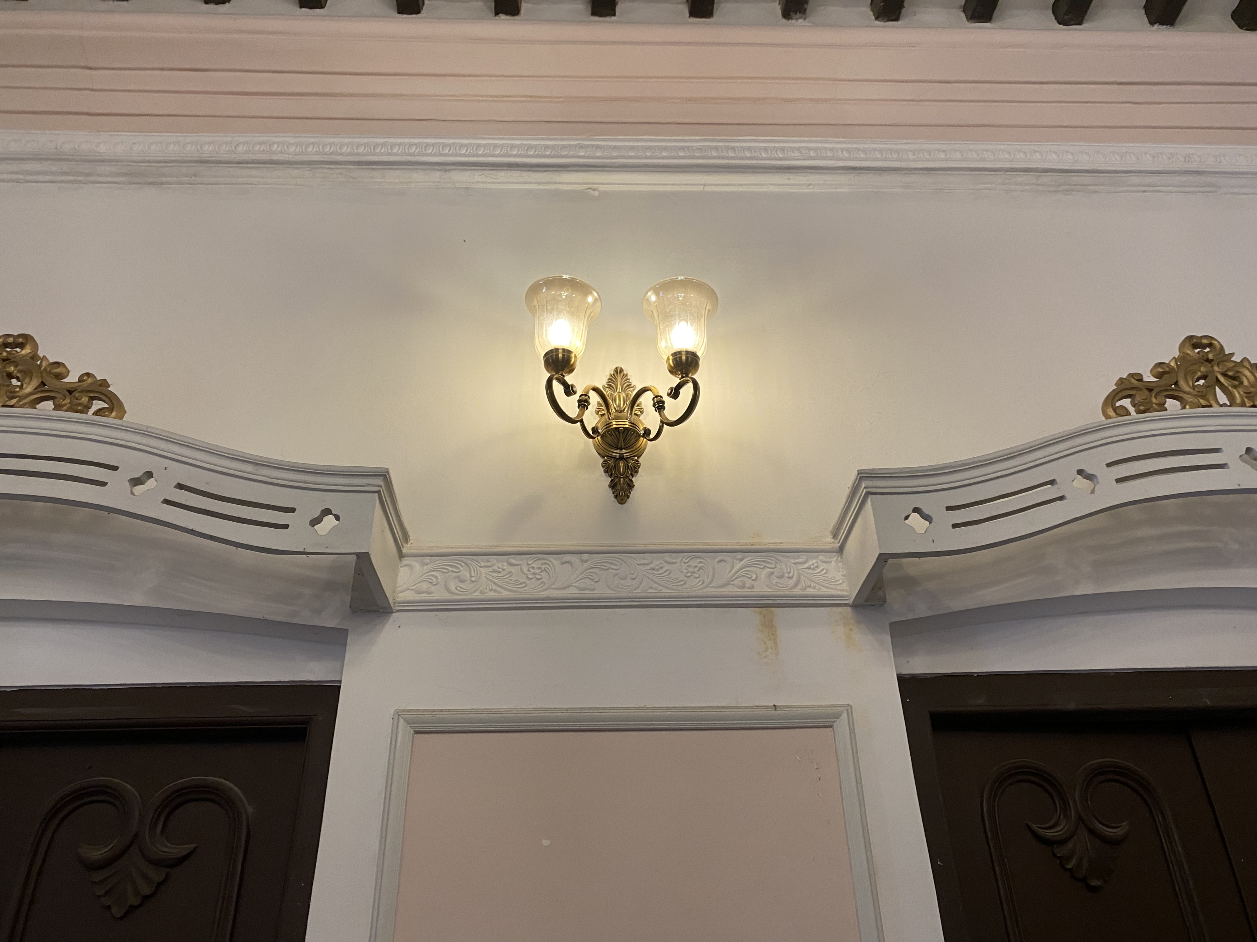 A decorative wall featuring a vintage-style sconce lamp, which emits a warm glow.