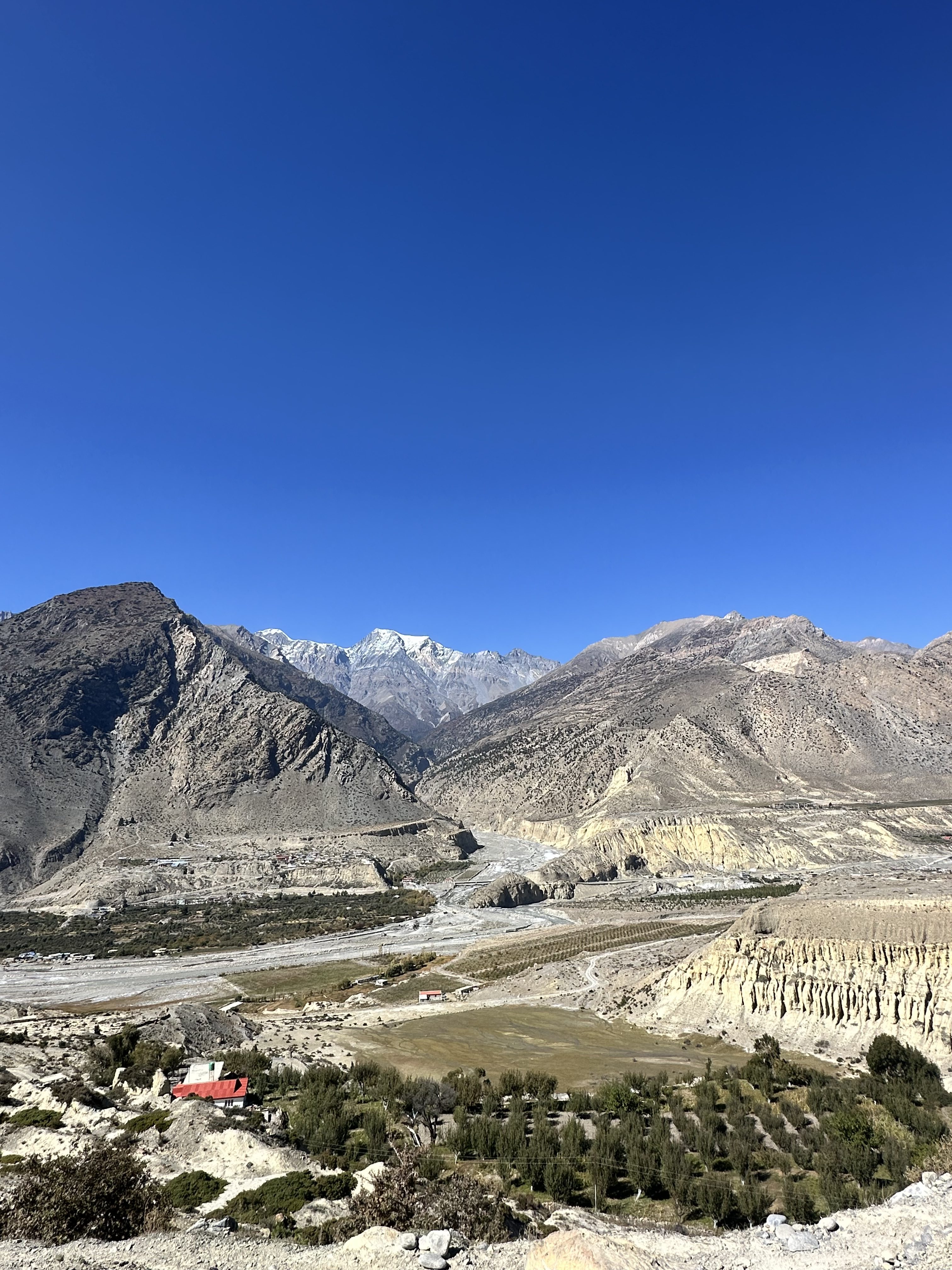 A panoramic view of the rugged mountainous landscape of Mustang under a clear blue sky.
