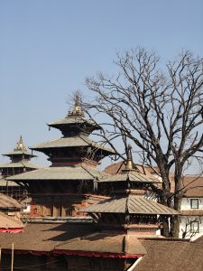 A view of traditional pagoda-style buildings with intricate architectural details, set against a clear blue sky.