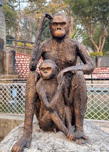 A bronze statue of two monkeys sits on a circular stone base.