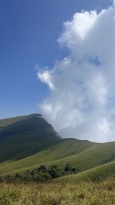 Netravathi Peak in the misty background under a blue sky.