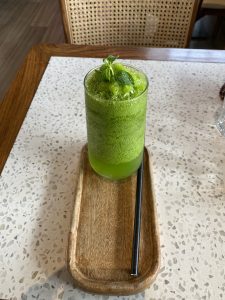 Fresh and vibrant, this green mint lemonade on a wooden tray is both refreshing and packed with nutrients.