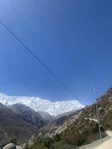 A scenic mountainous landscape featuring snow-capped peaks under a clear blue sky