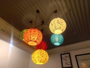A ceiling with colorful hanging lanterns in various shades including red, orange, green, yellow, and blue.