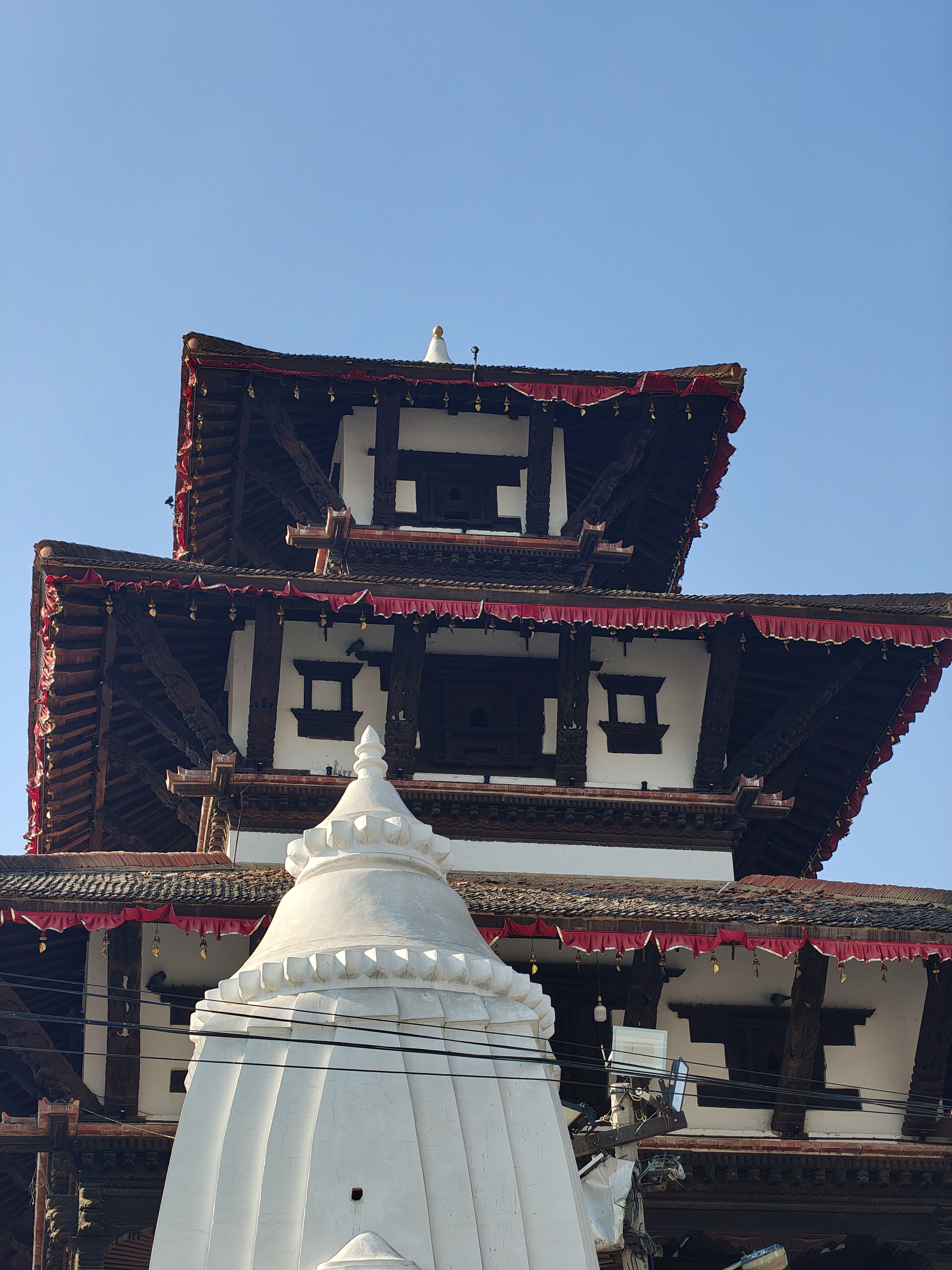 A tall, intricately designed multi-tiered structure with wooden beams and detailed carvings