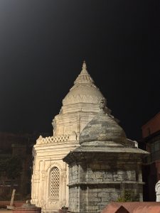 
A beautifully illuminated stone temple complex at night, featuring intricate architectural details