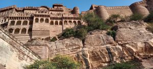 Large stone fort with arches and walls built into a hillside.
