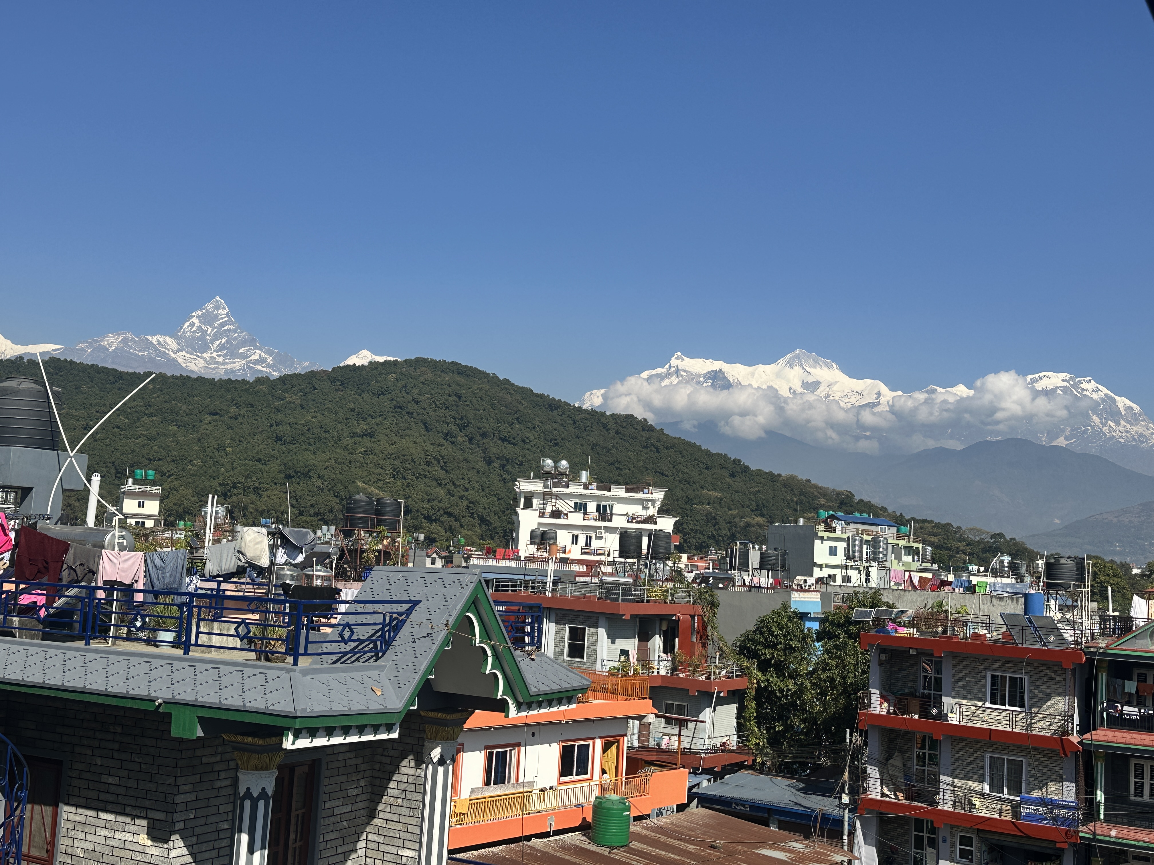 A scenic view of a mountainous landscape featuring snow-capped peaks under a clear blue sky. 