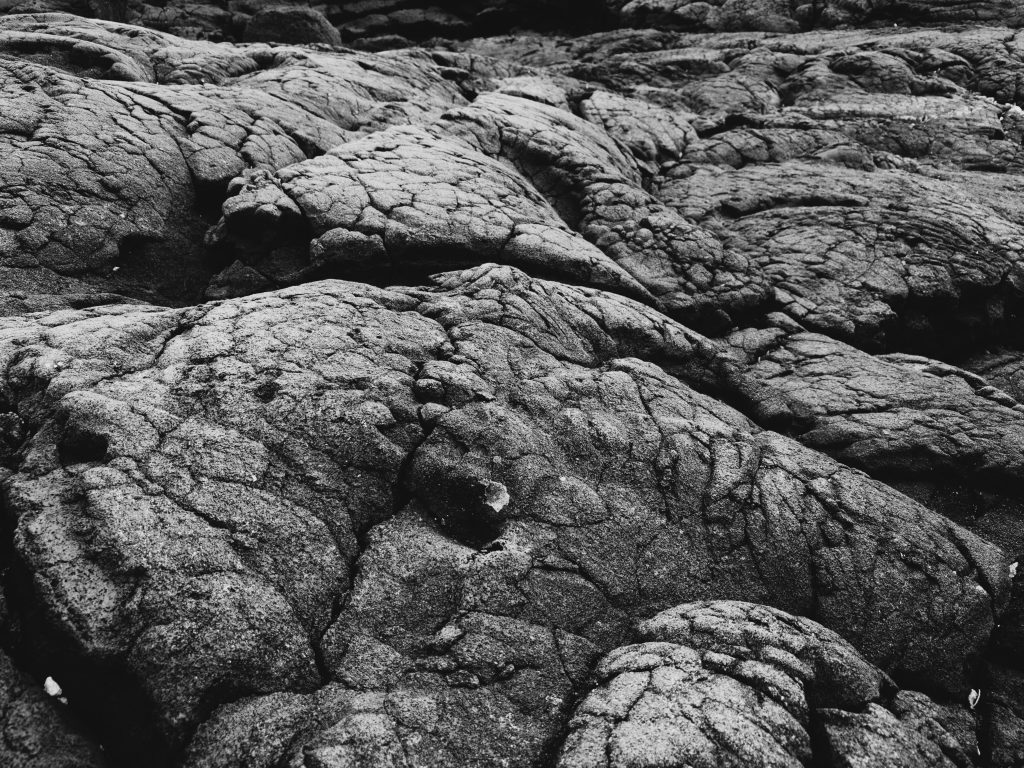 Black smooth and cracked ancient lava flow.