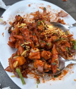 A close-up of Nimkin Chat, a popular Nepali snack made with crispy nimkin mixed with spices and sauce.