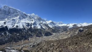 A breathtaking view of rugged mountains beneath a clear blue sky, captured from Bhraka, Manang, along the trail leading to Ice Lake.