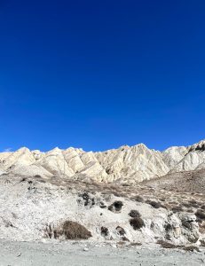 A rugged mountain landscape with light rocky peaks under a clear blue sky in Mustang.