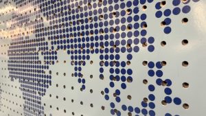 Blue dots on a pegboard, making the shape of the Earth’s continents.
