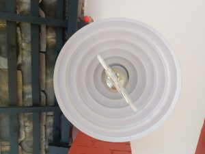 A ceiling light fixture viewed from below, featuring a circular design with concentric rings