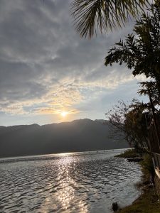 A serene landscape featuring a lake with shimmering water reflecting the sunlight