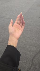 
A close-up of a woman's hand with long, natural-looking nails, stretched out palm-up.