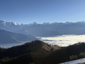 A breathtaking landscape featuring a panoramic view of snow-capped mountains in the background under a clear blue sky.