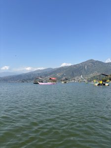 A serene view of a body of water with gentle ripples, dotted with several boats that have colorful canopies.