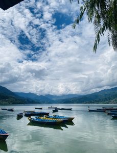 
A tranquil lake scene featuring numerous colorful wooden boats gently floating on the water.