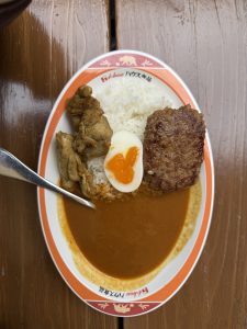 Japanese curry rice with meat and soft-boiled egg.