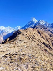 
A panoramic view of a mountainous landscape featuring snow-capped peaks under a clear blue sky.