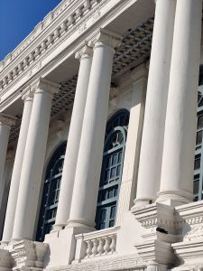 A close-up view of a classical building facade featuring tall, white columns with decorative capitals.