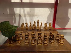 
A wooden chessboard setup featuring intricately carved wooden chess pieces