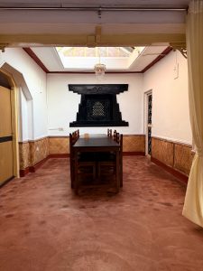 A spacious dining area featuring a long dark wooden table surrounded by chairs.