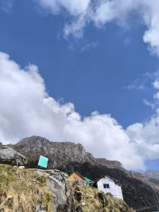 A picturesque mountain landscape with a clear blue sky dotted with fluffy white clouds.